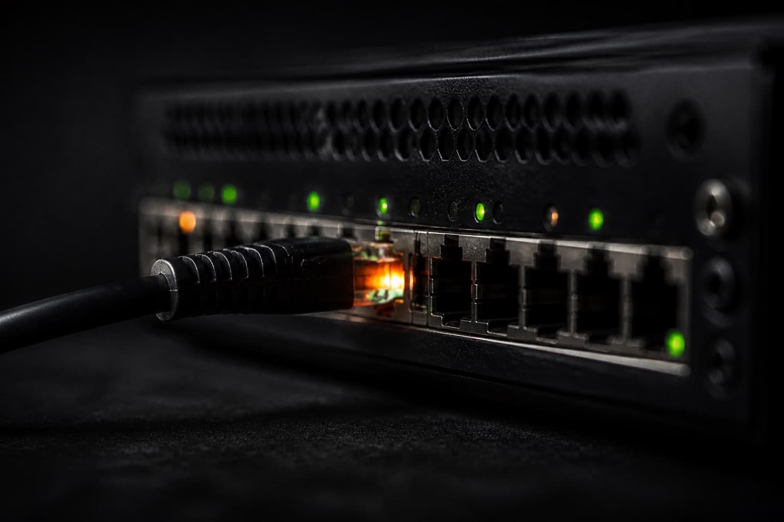 Macro photograph of a network switch with a single faintly glowing cable